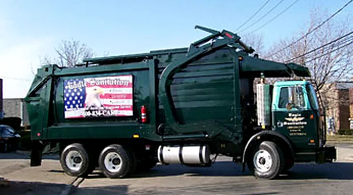 Side view of an Eagle Sanitation front load truck with the flag and eagle panel