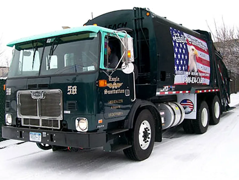 An Eagle Sanitation rear load truck, number 58, in green livery with the eagle and flag on its side